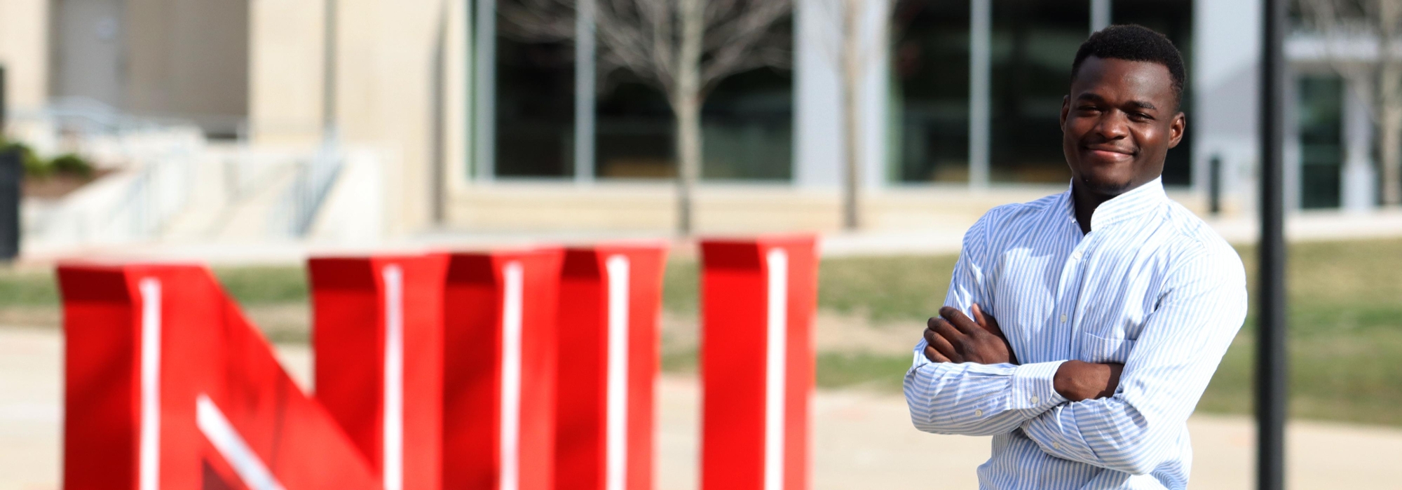 Transfer student, Ajibola Taiwo, poses near NIU statue.